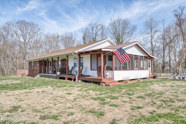 ranch-style home featuring fence, a porch, a front yard, and a sunroom