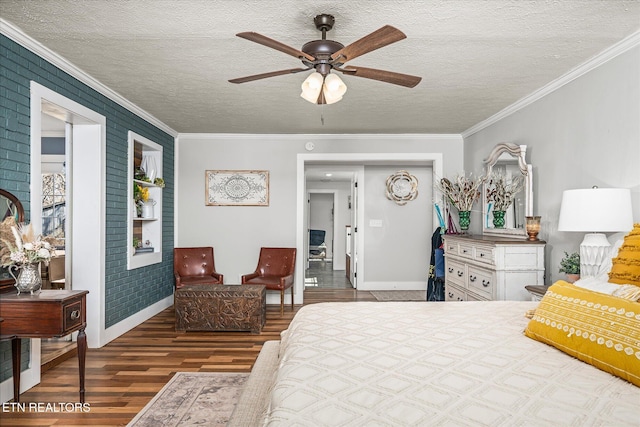 bedroom featuring baseboards, a textured ceiling, wood finished floors, and crown molding