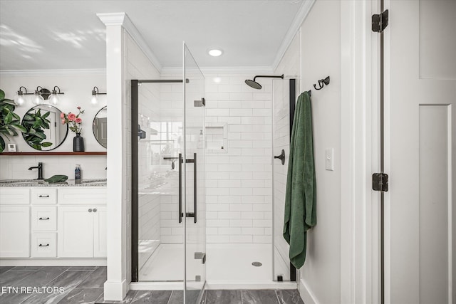 bathroom featuring marble finish floor, ornamental molding, a sink, a shower stall, and double vanity