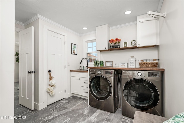 washroom with washing machine and clothes dryer, ornamental molding, cabinet space, marble finish floor, and a sink