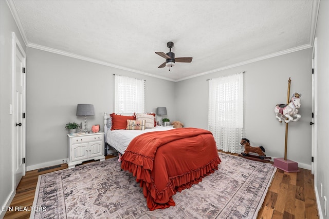 bedroom featuring crown molding, wood finished floors, baseboards, and a textured ceiling