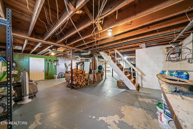 unfinished below grade area featuring stairs and concrete block wall