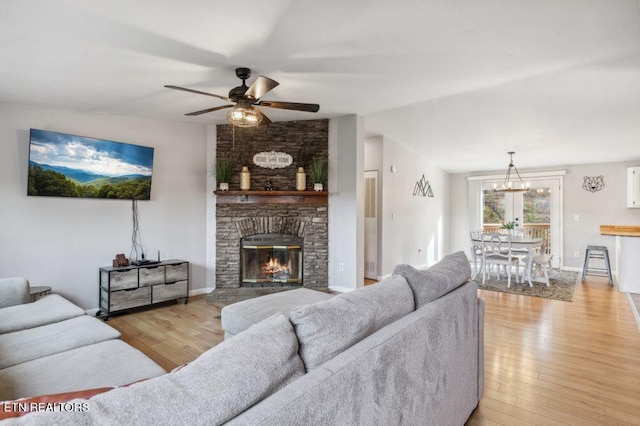 living room with lofted ceiling, light wood-style floors, a fireplace, and a ceiling fan