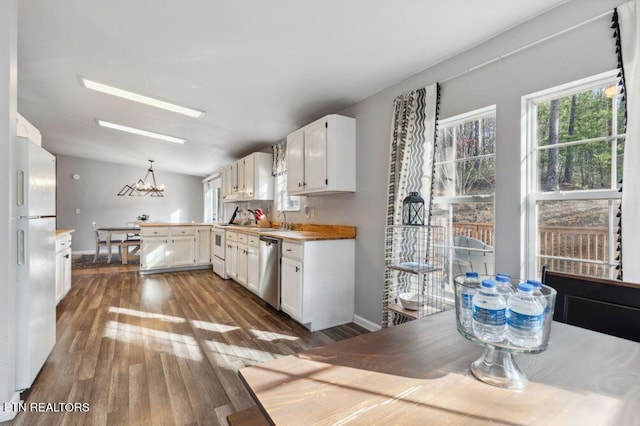 kitchen featuring white cabinetry, dark wood-style flooring, freestanding refrigerator, a sink, and dishwasher