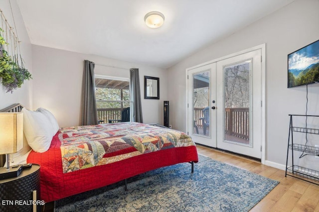 bedroom featuring access to exterior, french doors, baseboards, and wood finished floors