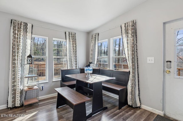 dining area with baseboards, lofted ceiling, and wood finished floors