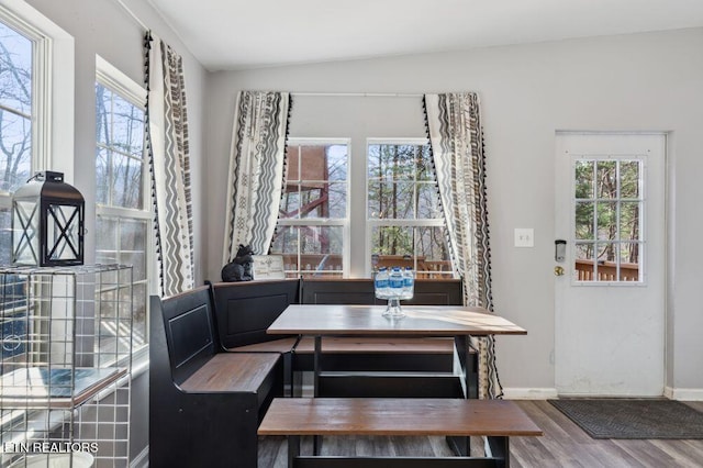 dining room with breakfast area, baseboards, lofted ceiling, and wood finished floors