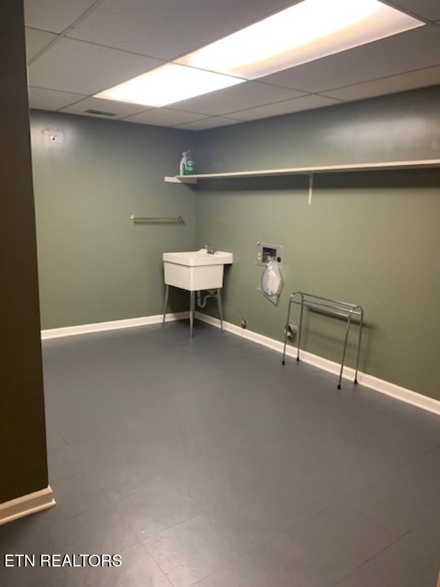 laundry area featuring laundry area, hookup for a washing machine, baseboards, and a sink