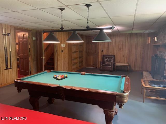 game room with a drop ceiling, wood walls, and pool table