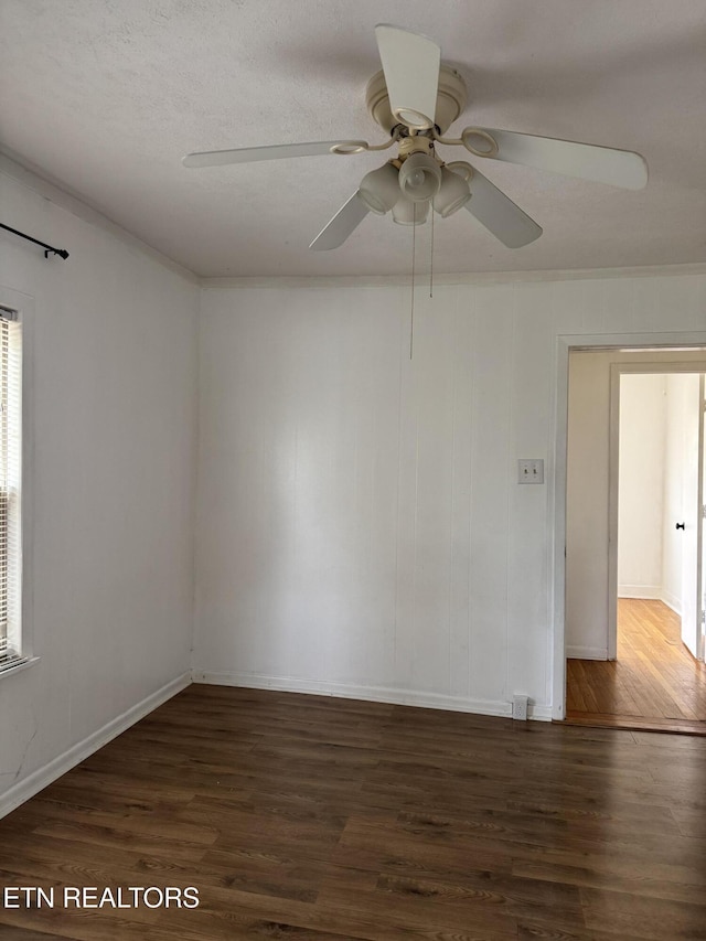 spare room with ornamental molding, baseboards, ceiling fan, and wood finished floors