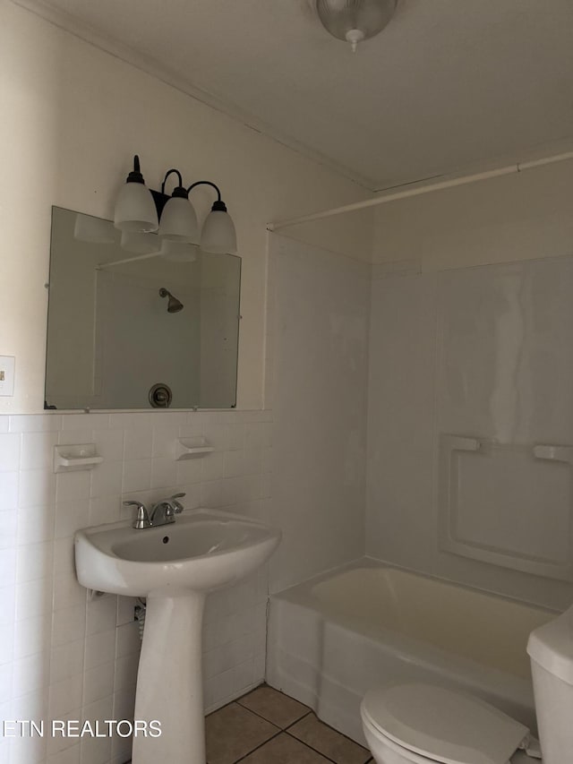 bathroom featuring toilet, tile walls, shower / washtub combination, and tile patterned flooring