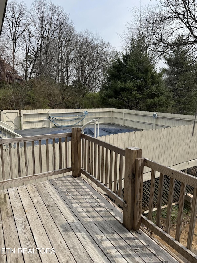 deck with a fenced in pool and fence