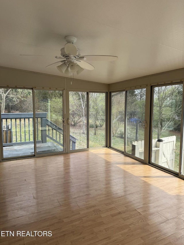 unfurnished sunroom with plenty of natural light and ceiling fan