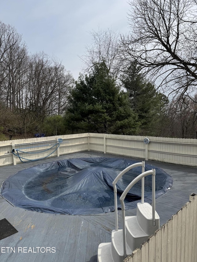 view of swimming pool featuring a fenced in pool, a wooden deck, and fence