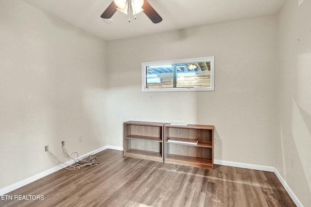 spare room with baseboards, a ceiling fan, and wood finished floors