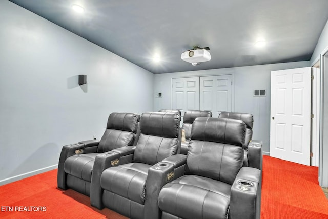 carpeted home theater room featuring visible vents and baseboards