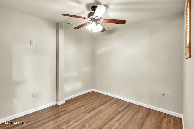 unfurnished room with wood finished floors, a ceiling fan, and baseboards
