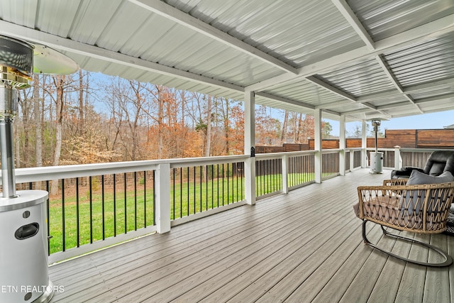 wooden terrace with a lawn and fence