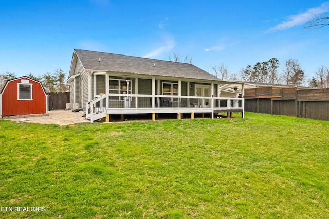 rear view of property with an outbuilding, a yard, a storage shed, and a fenced backyard