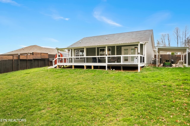 back of house with a fenced backyard, a lawn, and a wooden deck