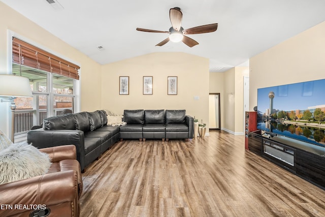 living area featuring visible vents, baseboards, ceiling fan, vaulted ceiling, and wood finished floors