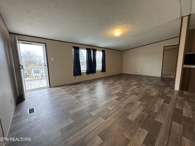 spare room featuring dark wood-style floors, visible vents, and a textured ceiling