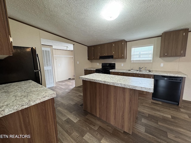 kitchen featuring a sink, black appliances, dark wood finished floors, and light countertops