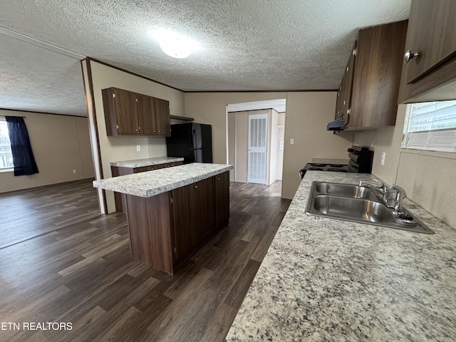 kitchen featuring a kitchen island, light countertops, dark wood-style floors, black appliances, and a sink