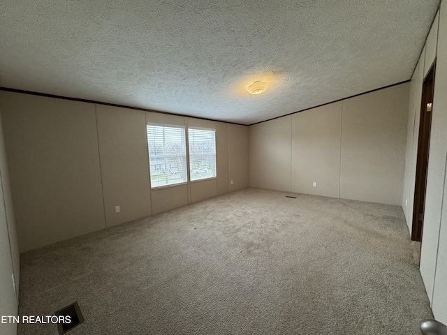 unfurnished room featuring a textured ceiling and carpet flooring