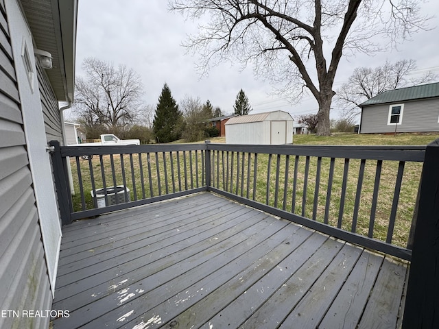 wooden terrace featuring an outbuilding, central air condition unit, a lawn, and a storage unit