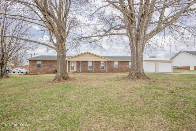 single story home with driveway, brick siding, and a front lawn