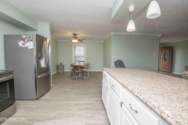 kitchen with light wood finished floors, a textured ceiling, stainless steel appliances, and ceiling fan