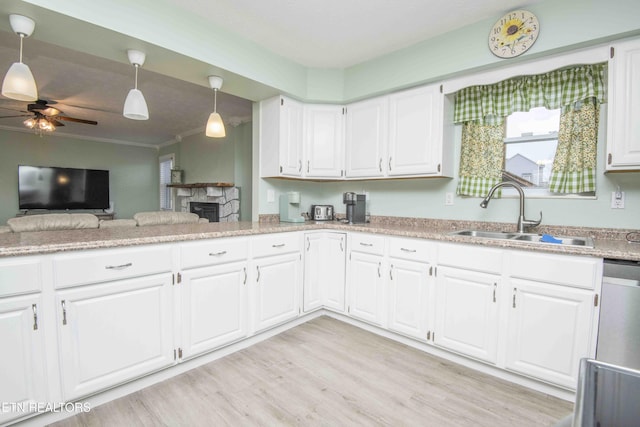 kitchen featuring a sink, ceiling fan, light wood-style floors, white cabinetry, and stainless steel dishwasher