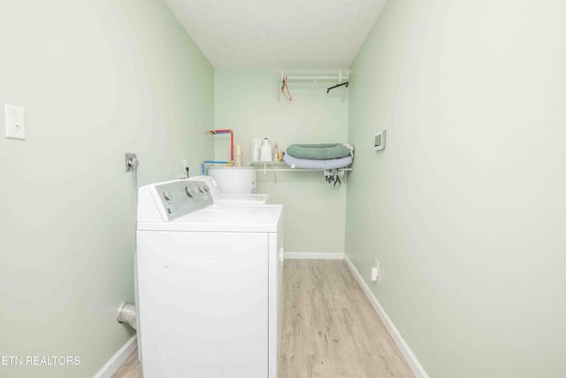 laundry room featuring light wood finished floors, laundry area, independent washer and dryer, and baseboards