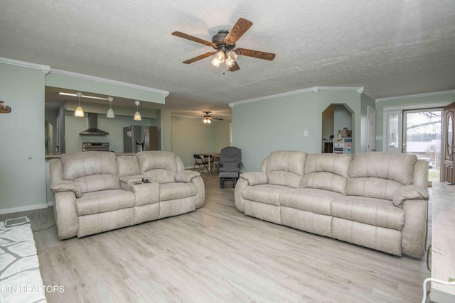 living room featuring ornamental molding, a textured ceiling, ceiling fan, and wood finished floors