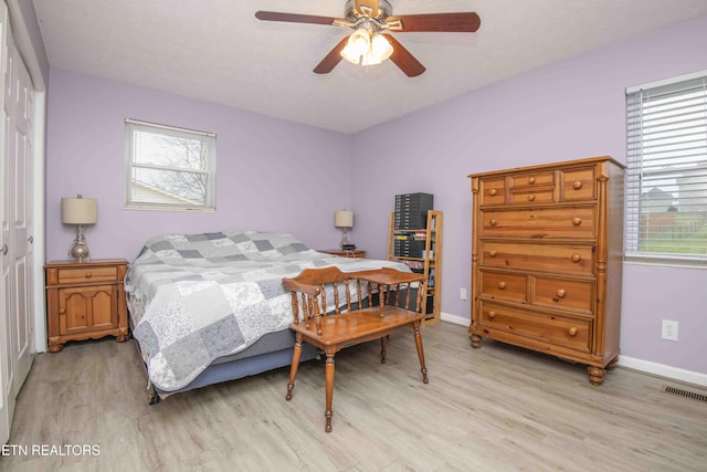 bedroom featuring visible vents, baseboards, a closet, and light wood-style flooring