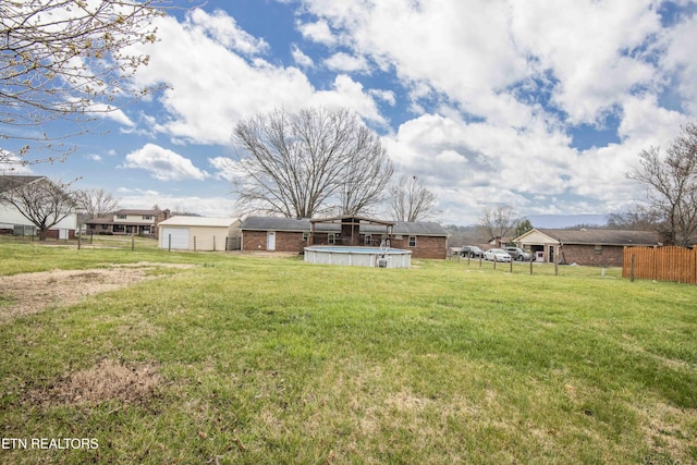 view of yard with a fenced in pool and fence