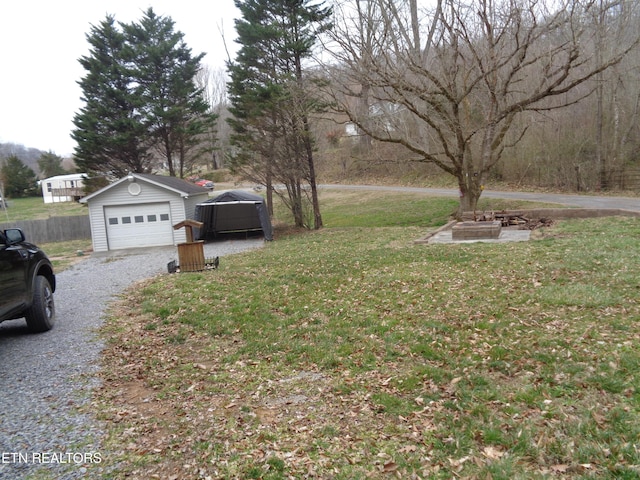 view of yard with a garage, gravel driveway, and an outdoor structure