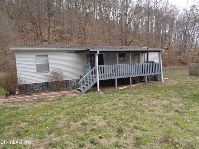 view of front of home featuring covered porch, metal roof, a front lawn, and fence