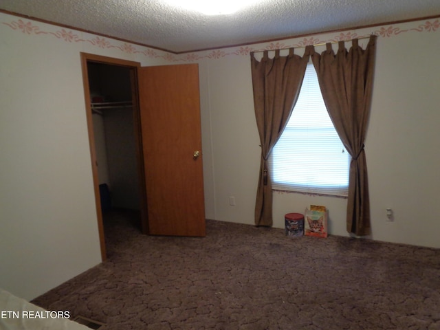 unfurnished bedroom featuring carpet, a closet, and a textured ceiling