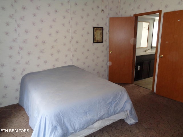 bedroom with a sink, connected bathroom, carpet flooring, and wallpapered walls