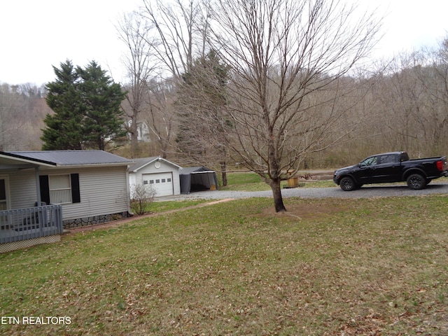 view of yard featuring an outbuilding, driveway, and a detached garage