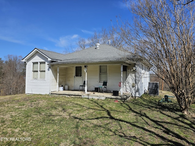 view of front of house with a patio, a front lawn, central AC unit, and a shingled roof