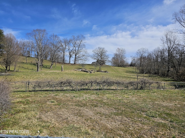 view of yard featuring a rural view and fence