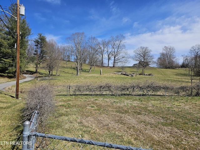 view of yard with a rural view and fence