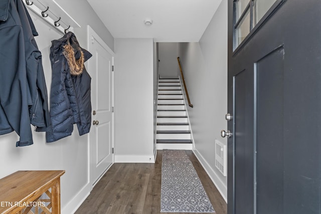 foyer with stairs, baseboards, and dark wood-style flooring