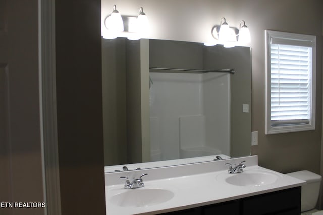 bathroom featuring a sink, walk in shower, and double vanity