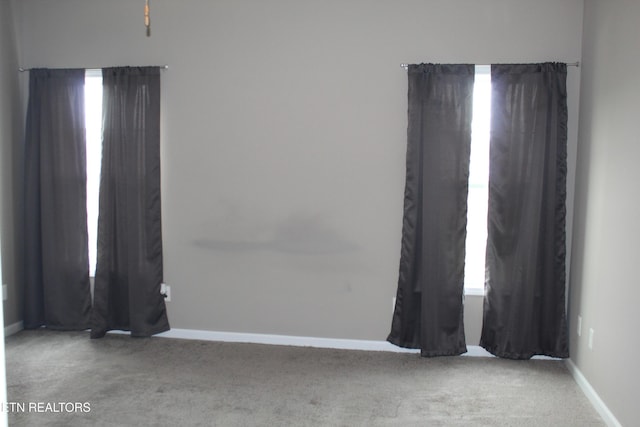 unfurnished room featuring baseboards and carpet flooring