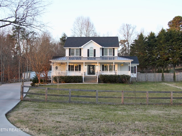 view of front of property featuring a porch, metal roof, a standing seam roof, and a front yard