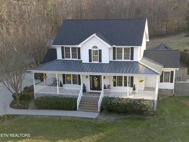 view of front of house featuring a front yard, a standing seam roof, a porch, crawl space, and metal roof